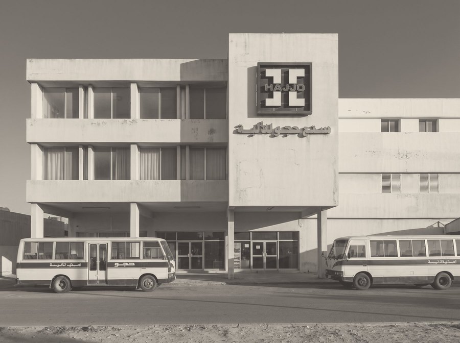 The Homs factory building from the street, the Hajjo sign on its front.